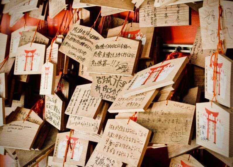 Tablillas ema: origen y actualidad - tablillas ema 3 Cientos de tablillas ema de madera con dibujos tradicionales colgadas en un estante emakake dentro de un santuario en japón