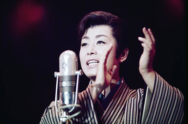 La voz de misora hibari y la reconstrucción emocional del japón de posguerra - singer hibari misora performs Misora hibari cantando en directo sobre un escenario, mostrando su técnica vocal característica del estilo tradicional japonés.