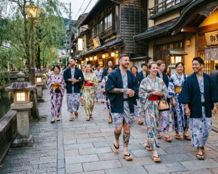 Cómo visitar un onsen en japón si tienes tatuajes: guía definitiva "tattoo friendly" - kinosaki onsen pueblo termal tatuajes yukata japon 2026 Turistas con tatuajes visibles pasean en yukata por kinosaki onsen en 2026, un pueblo termal famoso por su política de puertas abiertas en sus siete baños públicos