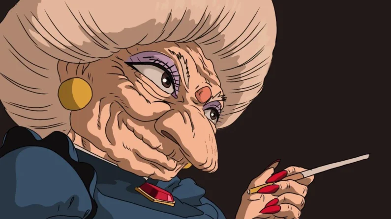 Guía completa de los yokais que aparecen en el viaje de chihiro - yubaba el vije de chihiro Primer plano de yubaba con expresión autoritaria en su oficina de el viaje de chihiro.