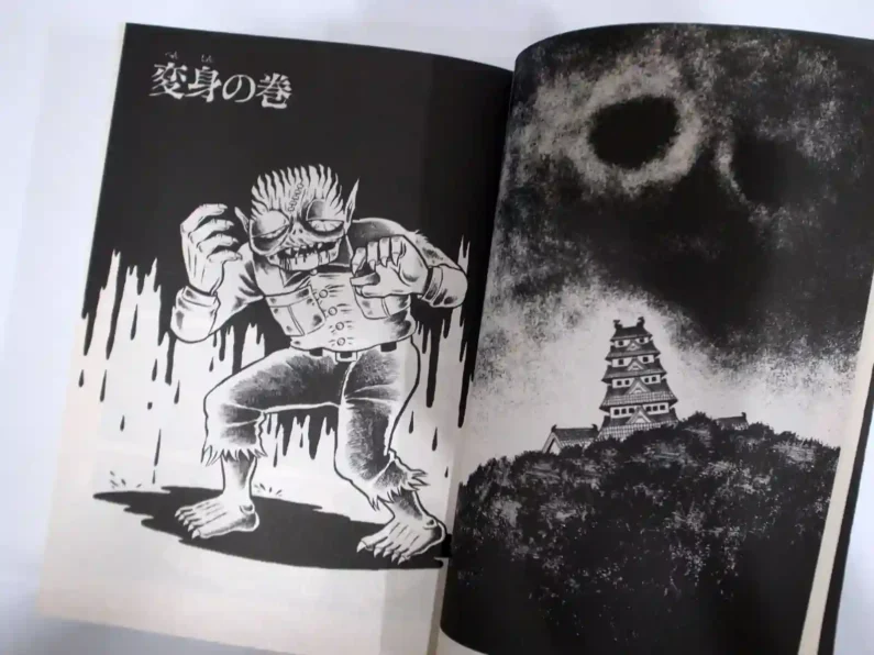 5 autores de manga de terror más perturbadores que junji ito - hideshi hino hijo del diablo interior Libro de manga abierto mostrando una viñeta en blanco y negro de un niño monstruoso del autor clásico hideshi hino.