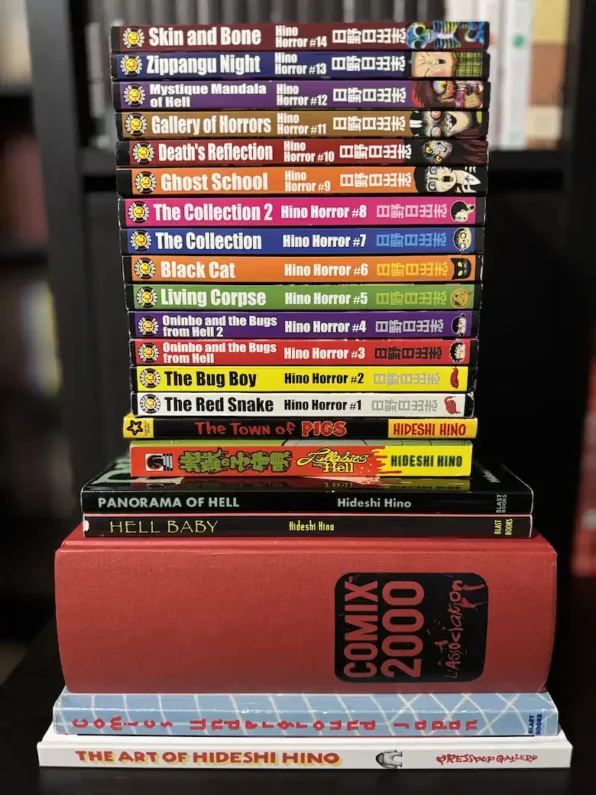 5 autores de manga de terror más perturbadores que junji ito - hideshi hino obras manga terror Pila de libros y tomos físicos de manga de terror de hideshi hino apilados verticalmente en una estantería oscura.