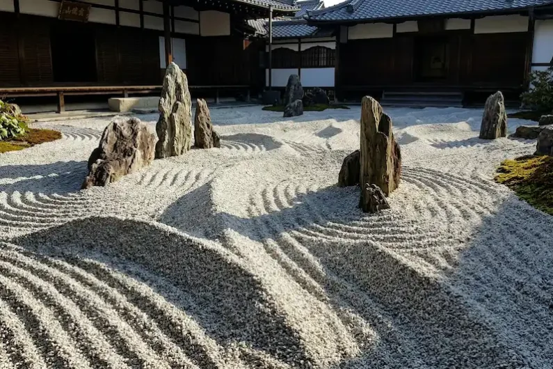 El arte del silencio y la piedra: guía para entender un jardín zen - jardin zen olas zuihoin daitokuji kioto Fotografía de un jardín japonés donde la arena blanca ha sido rastrillada con surcos muy altos y profundos formando olas que chocan contra piedras puntiagudas.