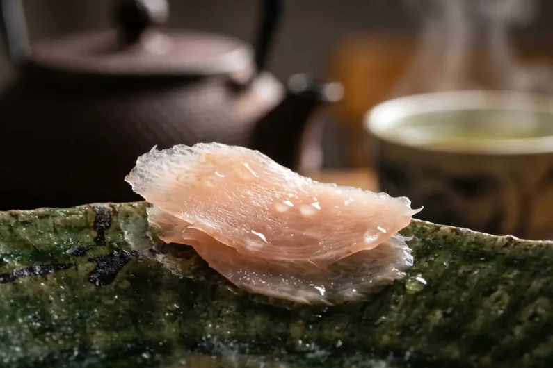 Los 10 errores más comunes al comer sushi en japón - jengibre encurtido gari sushi Primer plano extremo de una lámina translúcida de jengibre encurtido gari sobre un plato de cerámica artesanal